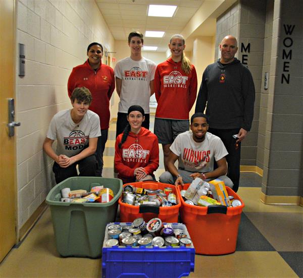 Members of the Boys and Girls basketball teams display the food items they collected to donate to the Chesco Food Bank 